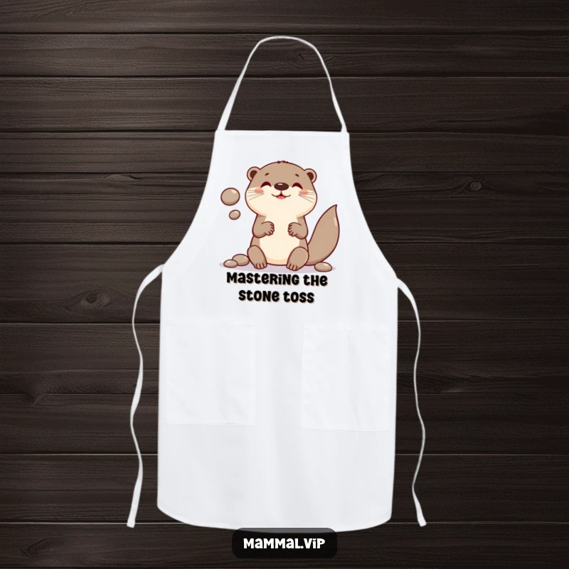 Funny apron showing a playful otter character in the middle of juggling smooth, round pebbles while cooking.