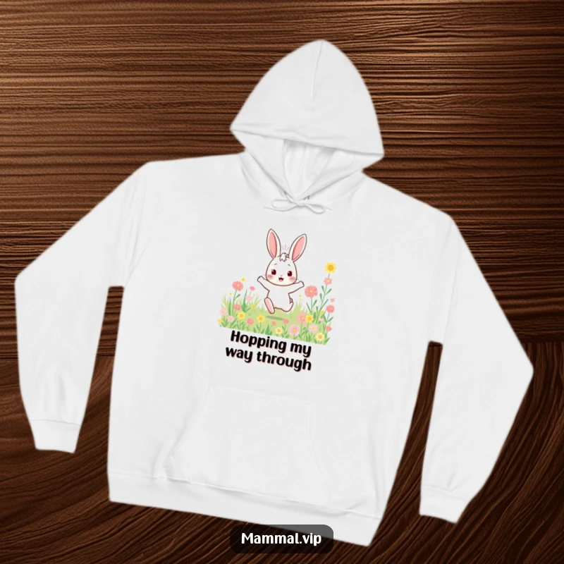 Funny bouncy rabbit hoodie with a character enthusiastically hopping through a field of flowers, offering warmth and vibrant cheer.